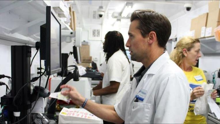 998e4d0e-Pharmacist Jeff Fabiano fills a prescription at a mobile pharmacy outside an evacuee shelter in Houston-404023