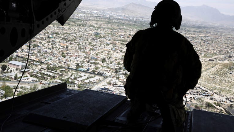 073fc886-A US soldier mans a weapon at the tailgate aboard the helicopter carrying US Defence Secretary James Mattis as he arrives at Resolute Support headquarters in the Afghan capital Kabul on April 24, 2017. (Photo credit should read JONATHAN ERNST/AFP via Getty Images)