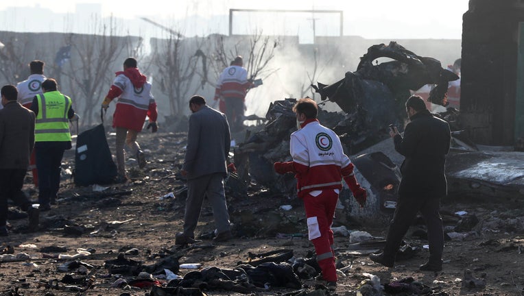 Rescue teams work amidst debris after a Ukrainian plane carrying 176 passengers crashed near Imam Khomeini airport in the Iranian capital Tehran early in the morning on January 8, 2020, killing everyone on board. 