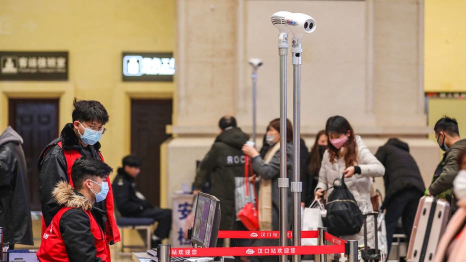 Staff members screen arriving passengers with thermal scanners at Hankou railway station in Wuhan, in China's central Hubei province on January 21, 2020. - Asian countries on January 21 ramped up measures to block the spread of a new virus as the death toll in China rose to six and the number of cases surpassed 300, raising concerns in the middle of a major holiday travel rush.