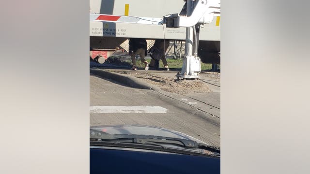 Fifth Ward students seen crawling through stopped train cars going to and from school