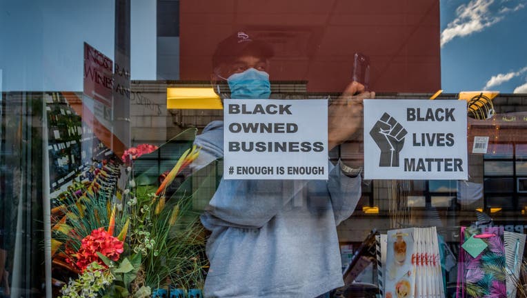 Open storefront displaying a Black Owned Business sign.