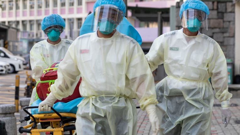 FILE - Medical staff wearing personal protective equipment (PPE) as a precautionary measure against the COVID-19 coronavirus approach Lei Muk Shue care home in Hong Kong on August 23, 2020. 