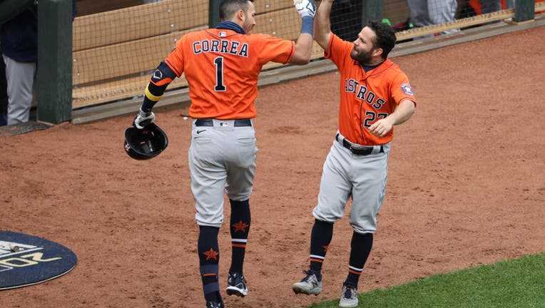 Carlos Correa #1 and Jose Altuve #27 of the Houston Astros celebrate after Correa hit a home run in the seventh inning of Game 2 of the Wild Card Series between the Houston Astros and the Minnesota Twins at Target Field on Wednesday, September 30, 2020 in Minneapolis, Minnesota.