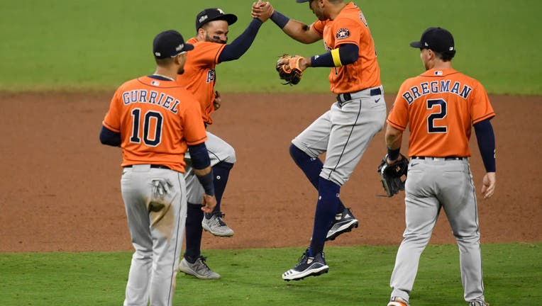 Jose Altuve #27 and Carlos Correa #1 of the Houston Astros celebrate a 7-4 win against the Tampa Bay Rays in Game Six of the American League Championship Series at PETCO Park on October 16, 2020 in San Diego, California.