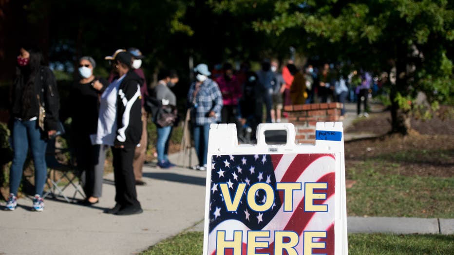 FILE - People line up outside the Richland County Voter Registration and Elections Office on the second day of in-person absentee and early voting on October 6, 2020 in Columbia, South Carolina. Polling places have opened in several counties for voters to drop off their ballots and vote early before Election Day on Nov. 3.