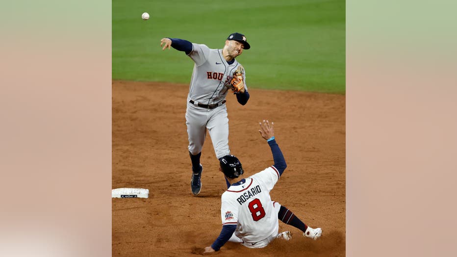 Austin Riley of the Atlanta Braves hits an RBI single in the sixth inning  of Game 4 of the World Series against the Houston Astros on Oct. 30, 2021,  at Truist Park