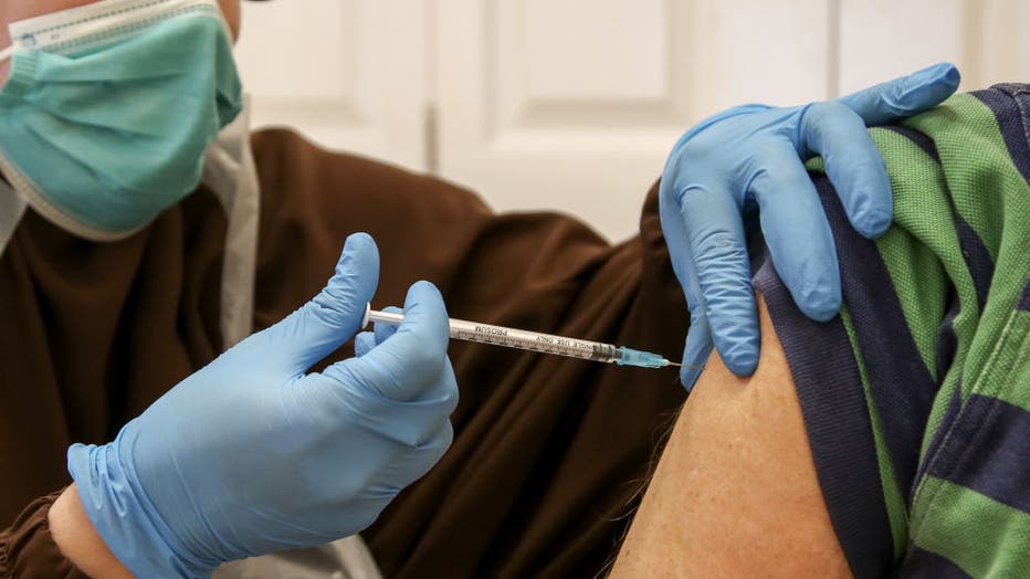 A health worker administers a dose of Pfizer/BioNTech Covid-