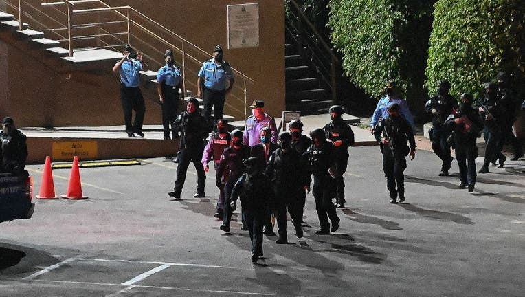 Special Forces' members take former Honduran President Juan Orlando Hernandez (C) into custody as the leave the Supreme Court of Justice after a judge granted his extradition to the US, in Tegucigalpa, on March 16, 2022. - A judge in Honduras on March 16, 2022 granted the extradition of former president Juan Orlando Hernandez to the United States where he is wanted for alleged drug trafficking, the Central American country's Supreme Court of Justice said on Twitter. (Photo by Orlando SIERRA / AFP) (Photo by ORLANDO SIERRA/AFP via Getty Images)