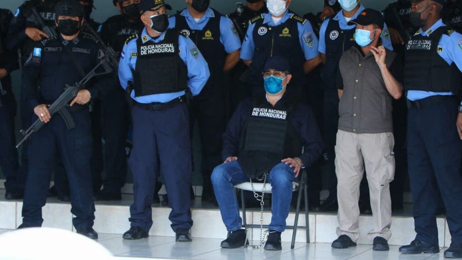 Honduran former President Juan Orlando Hernandez (C) is seen handcuffed at the headquarters of the Honduras Police, after receiving an extradition order from the United States in Tegucigalpa, on February 15, 2022. - The United States has asked Honduras to extradite its former president Juan Orlando Hernandez, who left office last month and is suspected of drug trafficking, a source close to the matter told AFP Monday. The Honduran Foreign Ministry had said earlier on Twitter that an "official communication from the US Embassy" had been sent to the Supreme Court formally asking for the provisional arrest of an unnamed "Honduran politician" for the purpose of extradition. (Photo by Str / AFP) (Photo by STR/AFP via Getty Images)