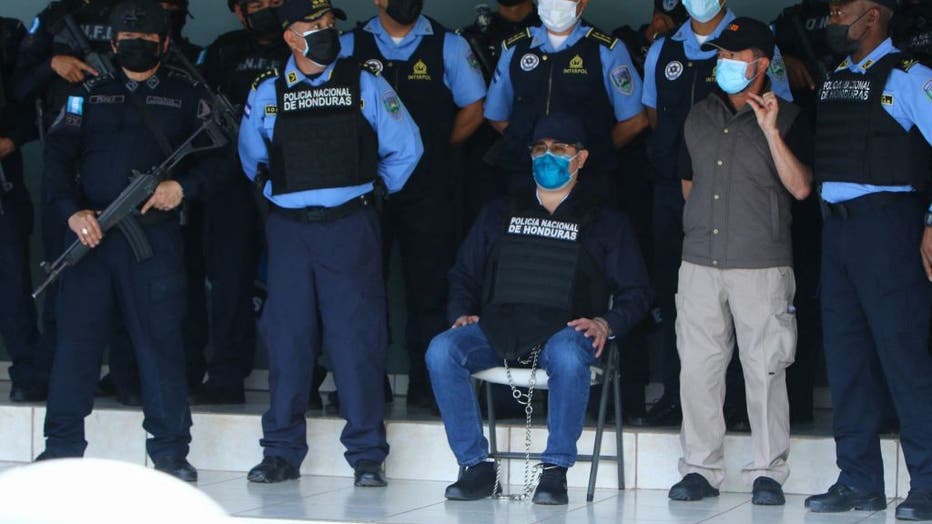 Honduran former President Juan Orlando Hernandez (C) is seen handcuffed at the headquarters of the Honduras Police, after receiving an extradition order from the United States in Tegucigalpa, on February 15, 2022. - The United States has asked Honduras to extradite its former president Juan Orlando Hernandez, who left office last month and is suspected of drug trafficking, a source close to the matter told AFP Monday. The Honduran Foreign Ministry had said earlier on Twitter that an "official communication from the US Embassy" had been sent to the Supreme Court formally asking for the provisional arrest of an unnamed "Honduran politician" for the purpose of extradition. (Photo by Str / AFP) (Photo by STR/AFP via Getty Images)