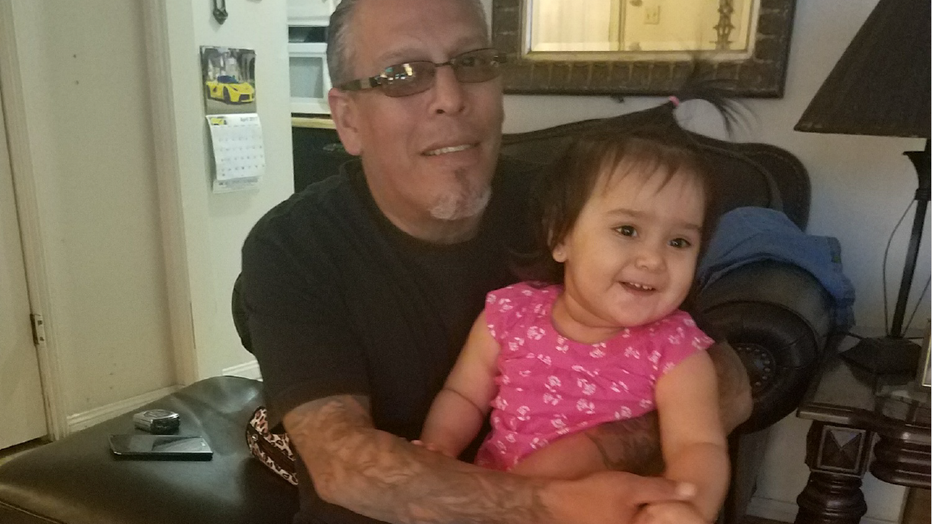 Picture of Christopher Flores with his grand daughter. The child's father died several years ago.