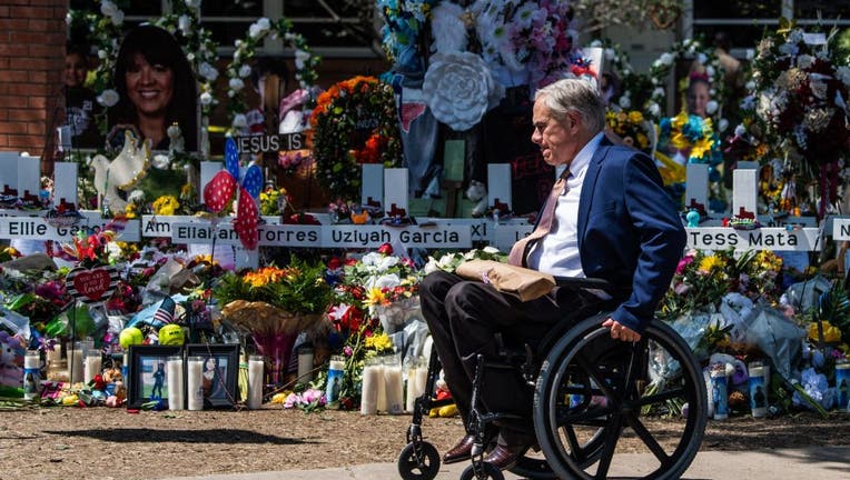 Texas Governor Greg Abbott arrives while US President Joe Biden and First Lady Jill Biden pay their respects at a makeshift memorial outside of Robb Elementary School in Uvalde, Texas