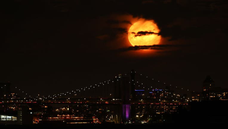 Hunter's Full Moon rises behind Brooklyn Bridge