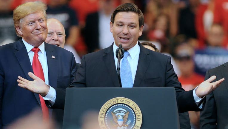 U.S. President Donald Trump looks on as Florida Governor Ron