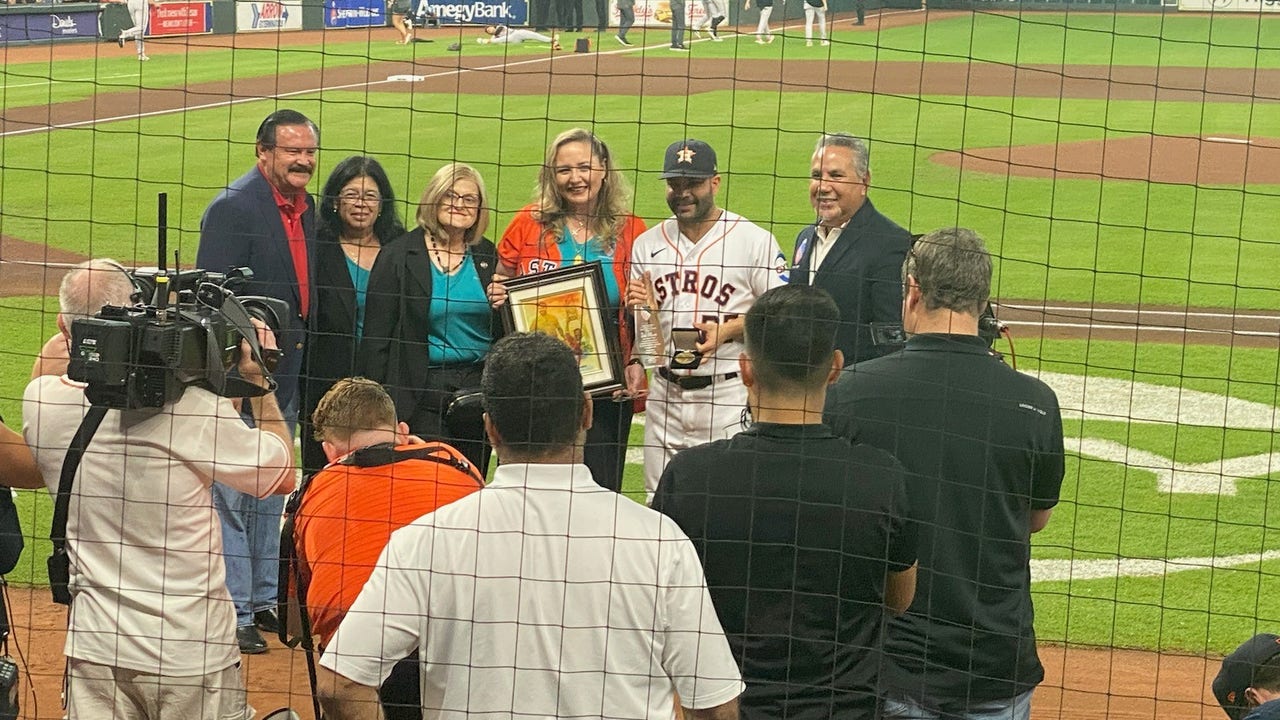 Love that Altuve is just standing there holding the trophy