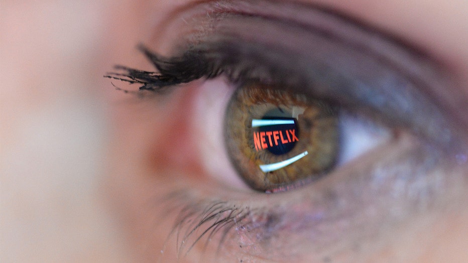 In this photo illustration the Netflix logo is reflected in the eye of a woman.