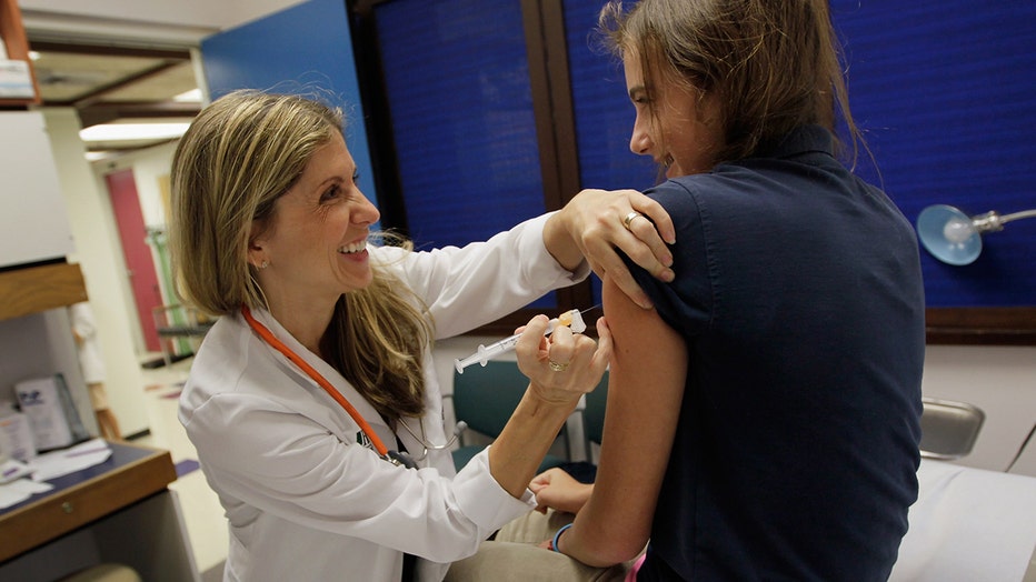 University of Miami pediatrician Judith L. Schaechter, M.D. gives an HPV vaccination to a 13-year-old girl in her office at the Miller School of Medicine on September 21, 2011 in Miami, Florida.