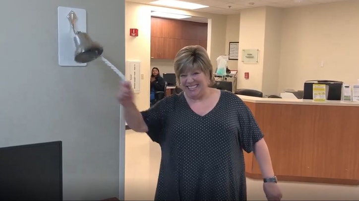woman ringing the cancer-free bell