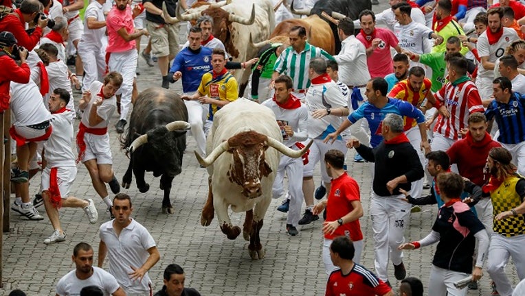 PAMPLONA, SPAIN - JULY 07: Revellers run with Puerto de San Lorenzo's fighting bulls before entering the bullring during the second day of the San Fermin Running of the Bulls festival. (Photo by Pablo Blazquez Dominguez/Getty Images)