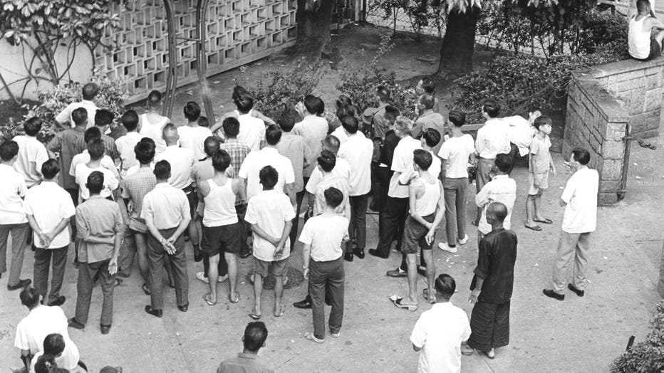 In a park, viewers gather around to watch the television broadcast of the Apollo 11 moon landing, Hong Kong, July 1969.