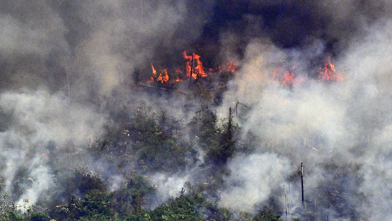 Aerial picture showing smoke from a two-kilometre-long stretch of fire billowing from the Amazon rainforest about 65 km from Porto Velho, in the state of Rondonia, in northern Brazil, on August 23, 2019. - Bolsonaro said Friday he is considering deploying the army to help combat fires raging in the Amazon rainforest, after news about the fires have sparked protests around the world. The latest official figures show 76,720 forest fires were recorded in Brazil so far this year -- the highest number for any year since 2013. More than half are in the Amazon. (Photo by Carl DE SOUZA / AFP) (Photo credit should read CARL DE SOUZA/AFP/Getty Images)