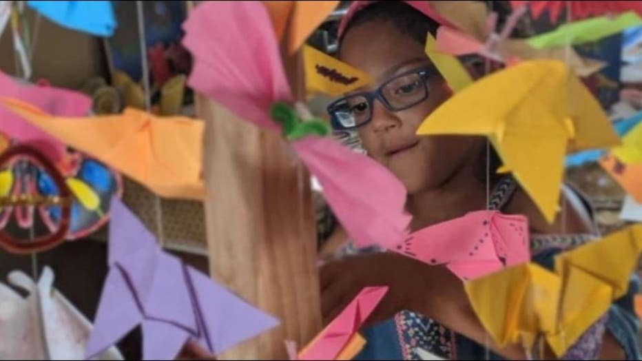 Lily Ellis, 10, stands with homemade butterflies to represent migrant children in U.S. detention facilities. Her goal, along with friend, Kaia Marbin, 11, is to create 15,000.
