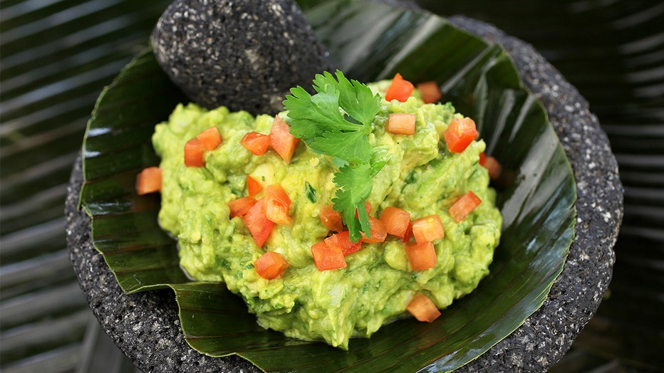 FILE: A bowl of guacamole is served in a mortar with pestle. Surging avocado prices this summer have caused some restaurants to serve