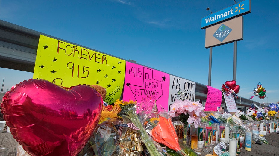 Flowers and signs at a makeshift memorial outside the El Paso, Texas, Walmart where a mass shooting occurred Saturday. Walmart has said that it will continue to sell guns and ammunition.