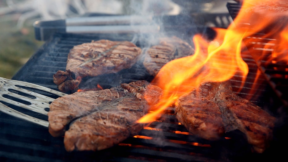 FILE: Salmon steaks being grilled over an open flame.