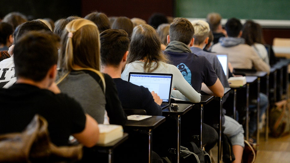 FILE - students sit in a lecture hall during a lecture.