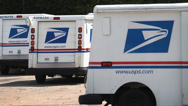 United States Postal Service (USPS) trucks are parked at a postal facility.