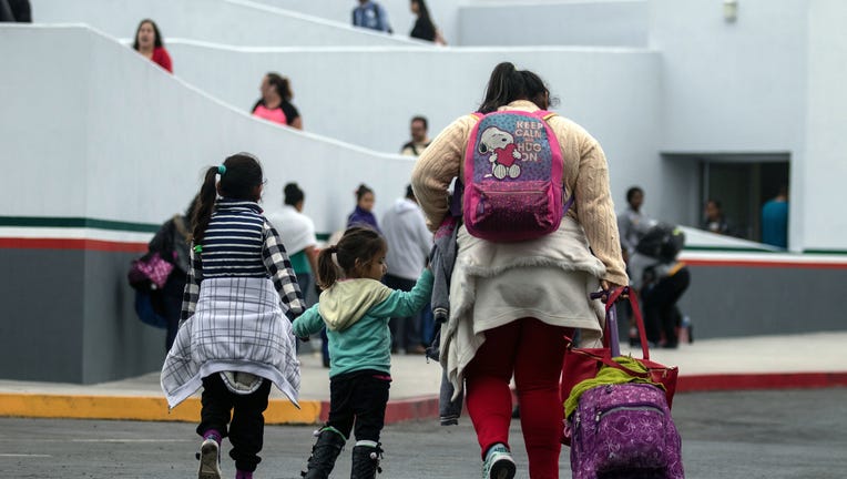 Migrants walk towards El Chaparral port of entry in Tijuana, Mexico, in the boder with the United States on June 21, 2018. - US lawmakers were poised to vote Thursday on long-term Republican-sponsored fixes to immigration amid a firestorm over family separations on the US-Mexico border. (Photo by GUILLERMO ARIAS / AFP) (Photo credit should read GUILLERMO ARIAS/AFP via Getty Images)