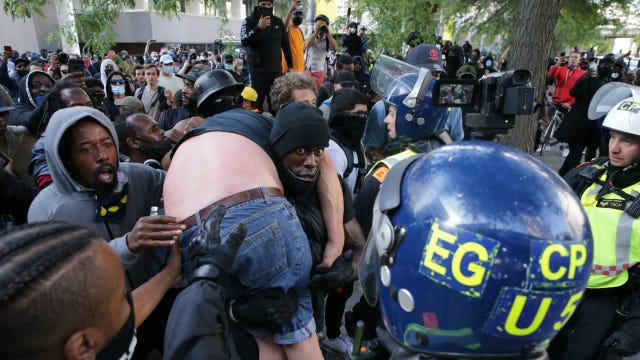 Black protester carries white man through angry crowd to safety to 'stop someone from being killed'