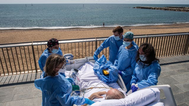Hospital staff in Spain wheels recovering coronavirus patients to the beach