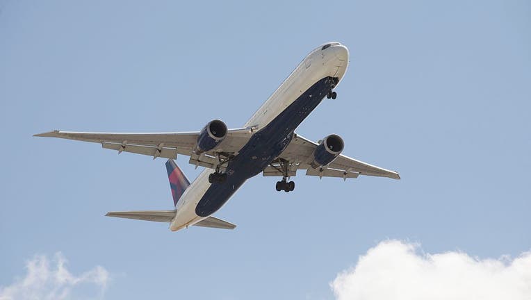 A Delta 767 400 passenger jet with landing gear down in preparation to land