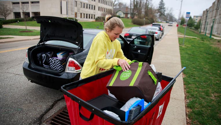 Indiana University freshman Ashley Follmer moves items from