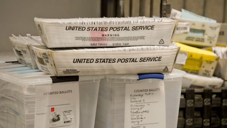 FILE - Stacks of mail-in ballots.