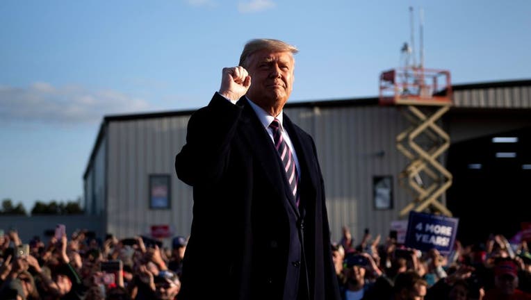 US President Donald Trump pumps his fist as he arrives for a rally in Minnesota