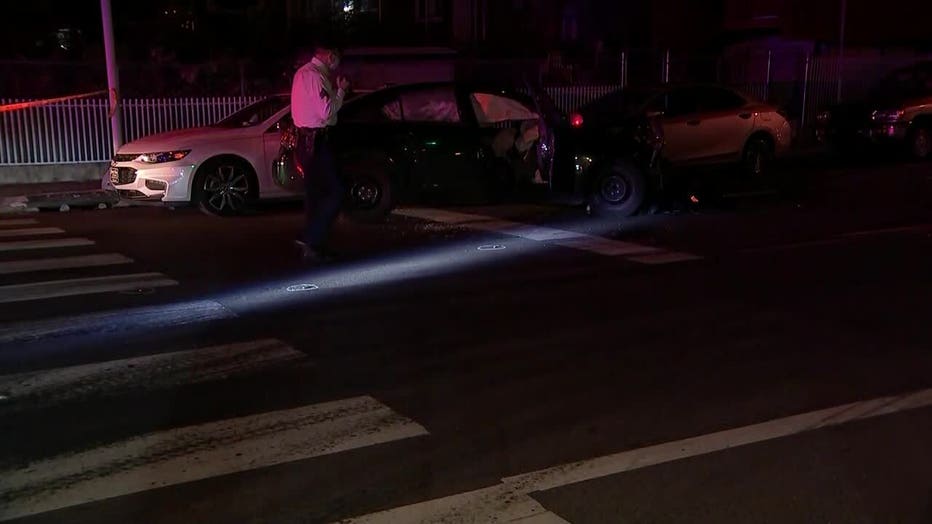 Investigators survey the scene after a woman was shot and later involved in a car crash in Juniata Park. 