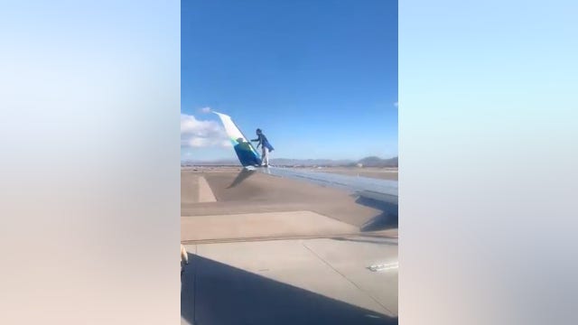 Man climbs onto commercial jet wing at Las Vegas airport, falls and gets arrested, videos show