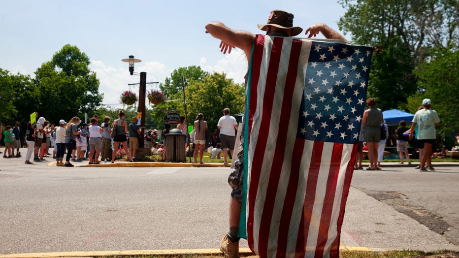 A man holds an American flag during the demonstration.
