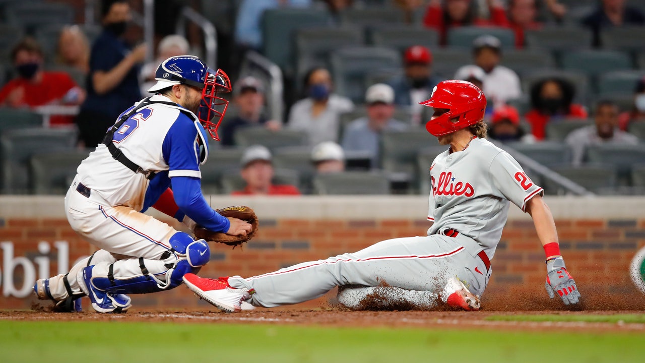 Ozzie Albies of the Atlanta Braves tags out J.T. Realmuto of the