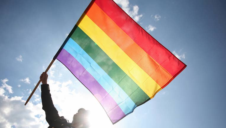 A Polish wave a rainbow flag as he takes