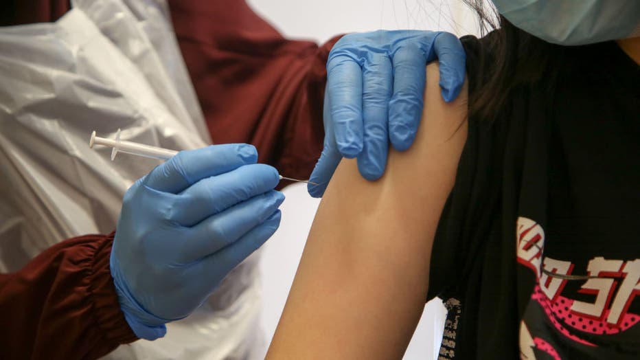 A NHS vaccinator administers the Pfizer Covid-19 vaccine to