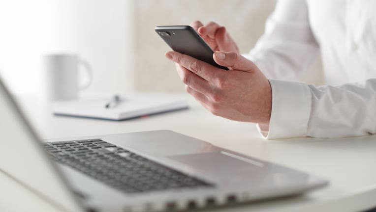 Businessman Using Smartphone And Laptop