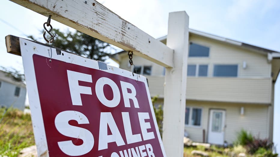 For sale by owner sign hangs in front of Long Island house