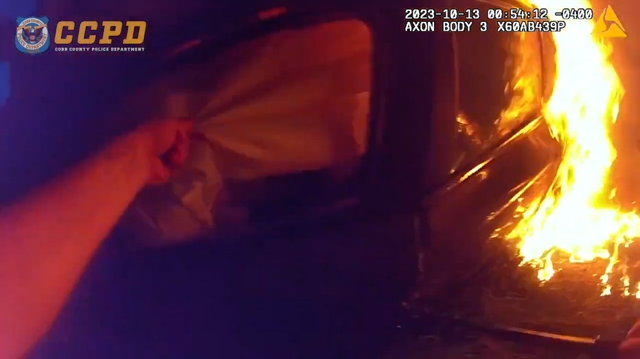 Dramatic video shows officer pull woman from burning car after she