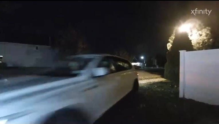 A security video screenshot, showing a white SUV rapidly approaching the camera.