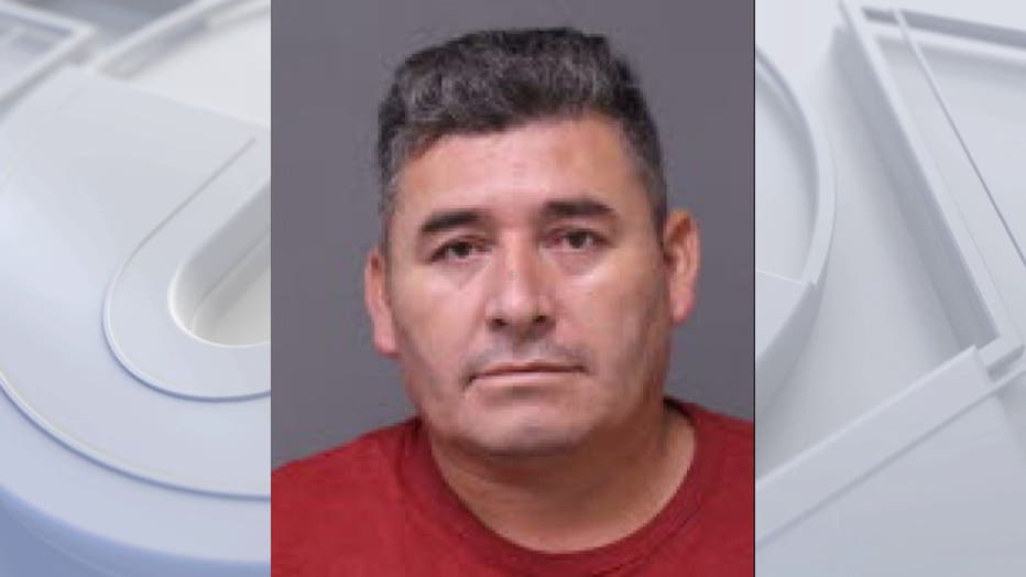 A mugshot of a man with a flat top haircut and red shirt.